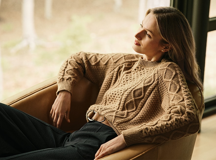 A woman in a sweater sitting on a chair
